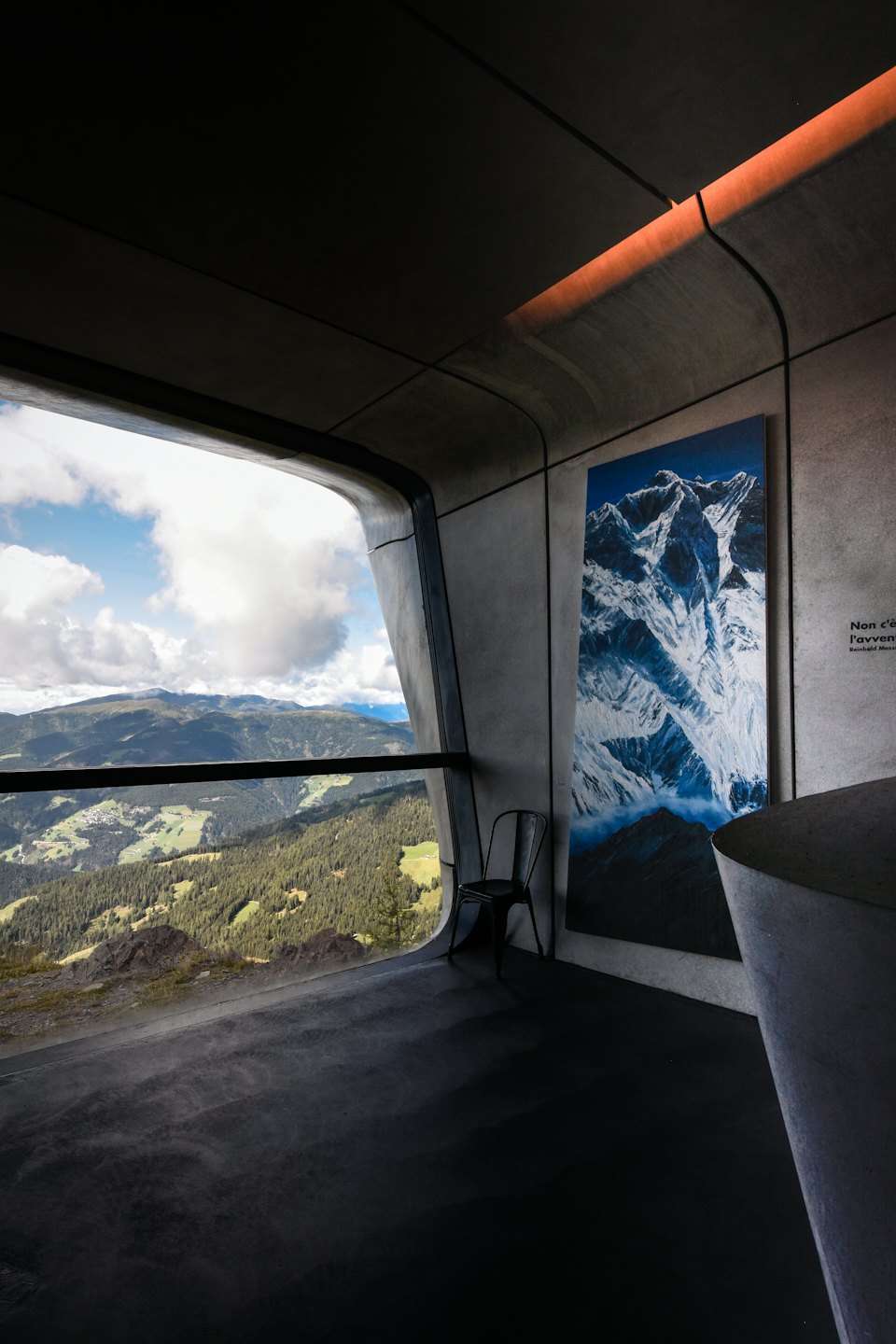 Modern room with concrete walls and mountain view.