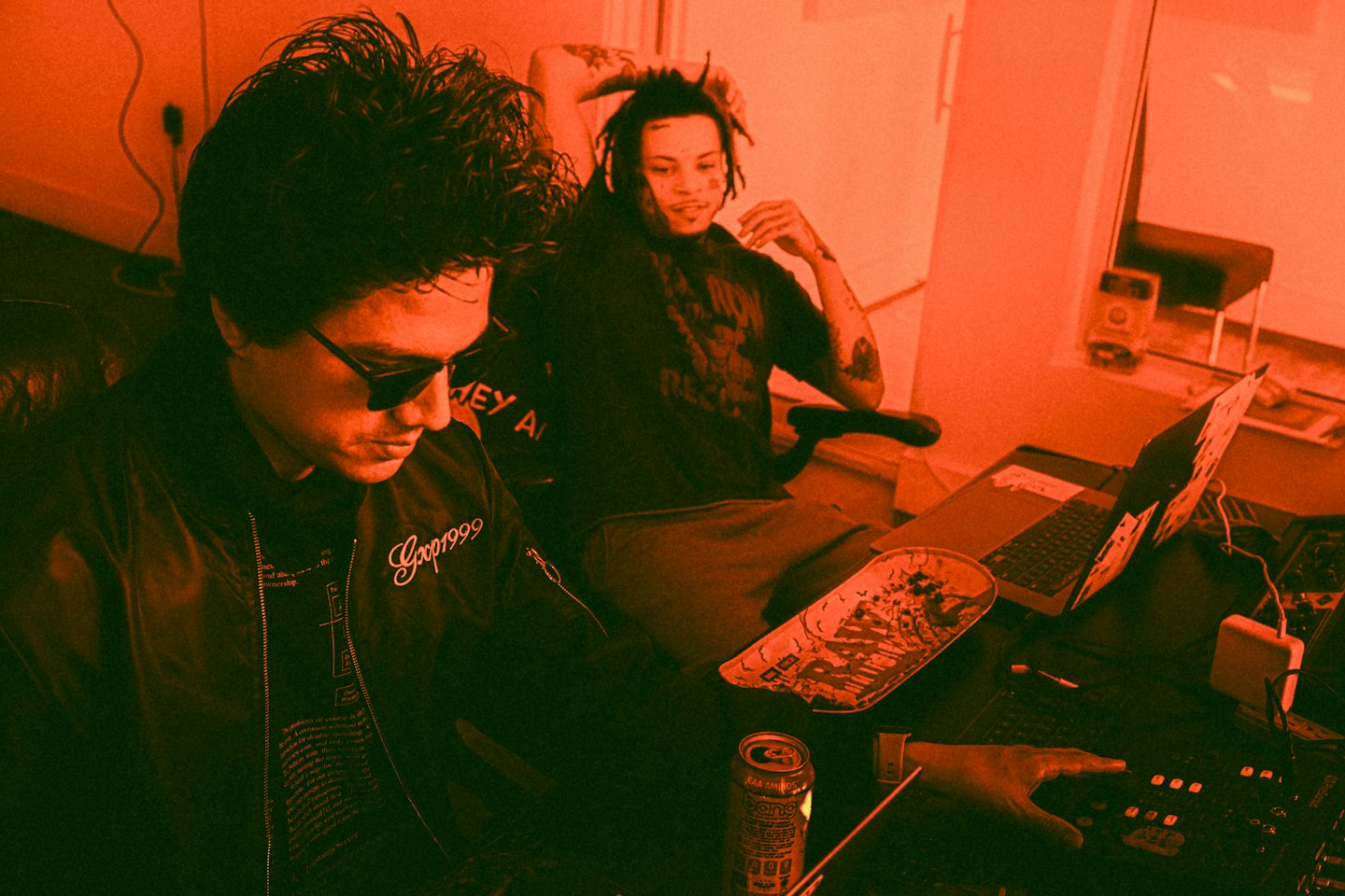 Two men collaborate on music production inside a studio.